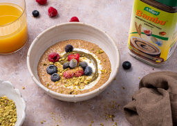 Bol d’overnight oats à la poudre Bambu avec fruits rouges et pistaches, servi avec un substitut naturel au café sans caféine.
