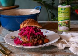 Sandwich coq au vin avec poulet mijoté, chou rouge et sel aux herbes Herbamare, servi comme repas chaud.