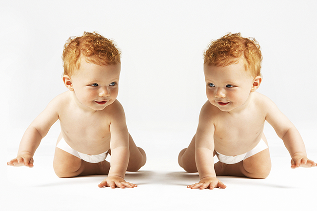 Identical ginger twins looking at each other in studio