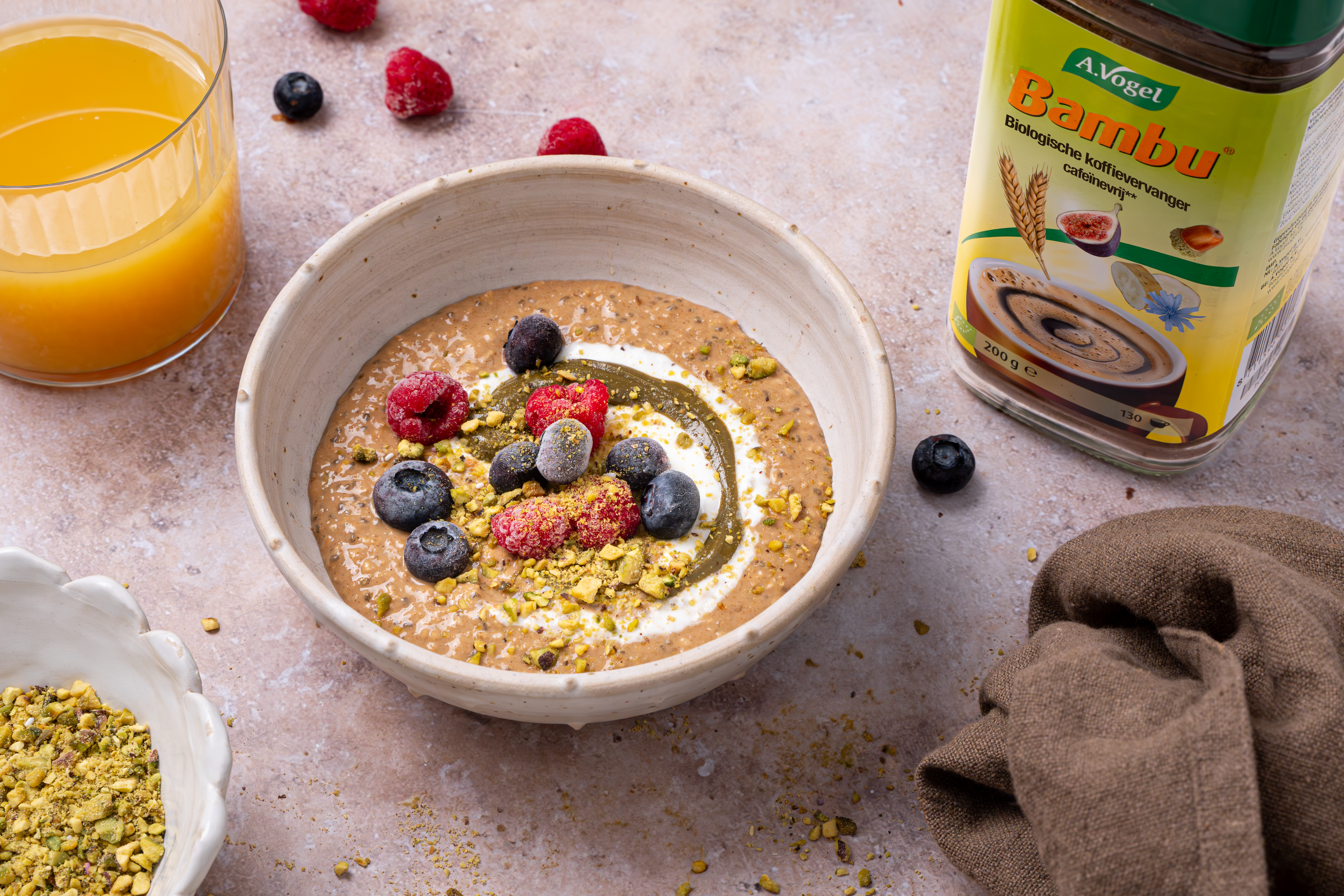 Bambu overnight oats in een kom met banaan, rood fruit en pistachenootjes, bereid met Bambu-poeder als natuurlijke koffievervanger.