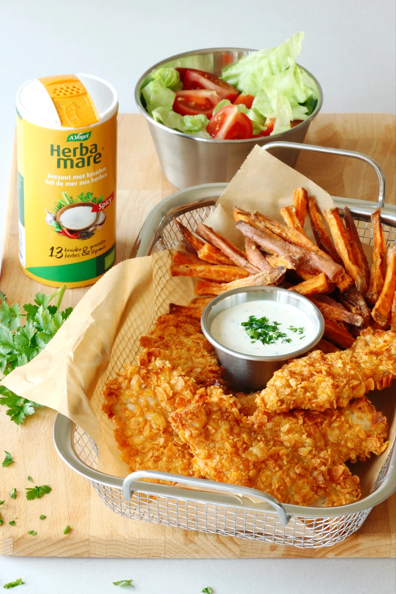 Spicy zoete aardappelfrietjes met krokante chicken tenders en yoghurtsaus met Herbamare Spicy kruidenzout